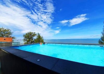 Outdoor infinity swimming pool overlooking the sea with clear blue sky