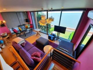 Spacious living room with floor-to-ceiling windows offering ocean views