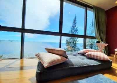 Spacious bedroom with floor-to-ceiling windows overlooking the ocean