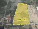 Aerial view of a vacant land plot highlighted for property listing
