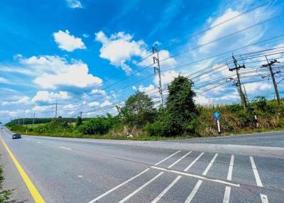 Wide road with clear blue sky and lush greenery on the sides