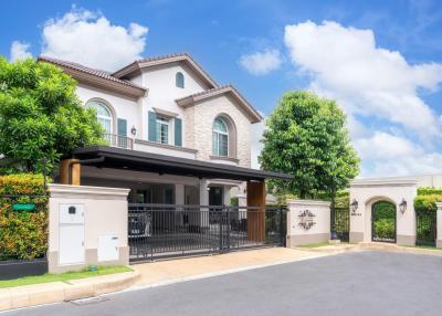 Elegant two-story house with a gated entrance and landscaped front yard