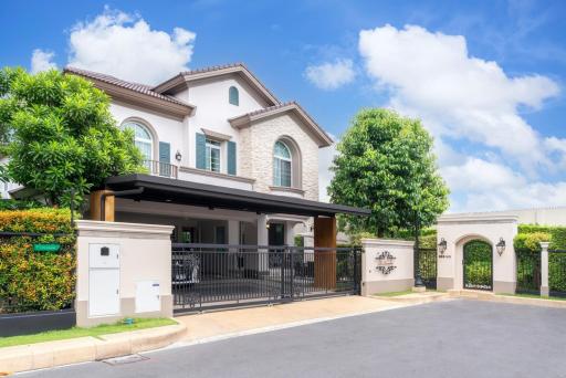 Elegant two-story house with a gated entrance and landscaped front yard