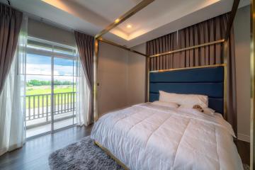 Modern bedroom with a large window and golf course view