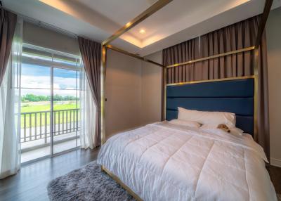 Modern bedroom with a large window and golf course view