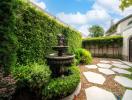 Elegant garden pathway with lush greenery and a classic fountain