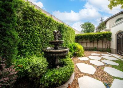 Elegant garden pathway with lush greenery and a classic fountain