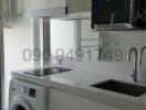 Compact modern kitchen with built-in appliances and washing machine