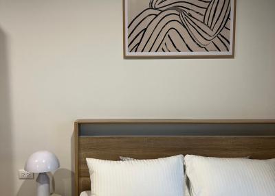 Modern minimalist bedroom with wall art over the bed