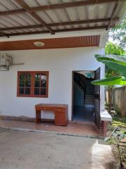 Exterior view of a house entrance with tiled patio and stairs