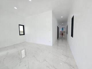 Spacious and bright empty room with white walls and marble flooring