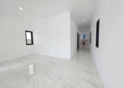 Spacious and bright empty room with white walls and marble flooring