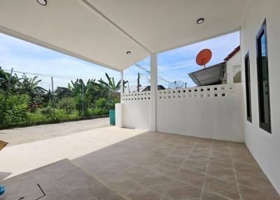Spacious covered patio with tiled flooring and white fencing