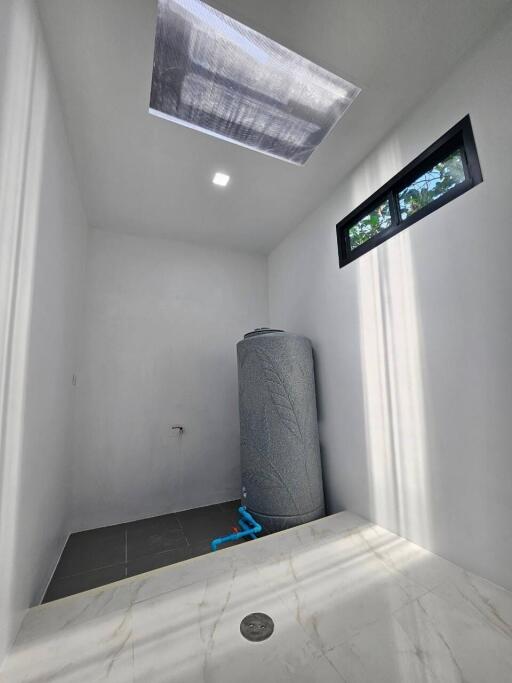 Compact utility room with a large water heater and natural light