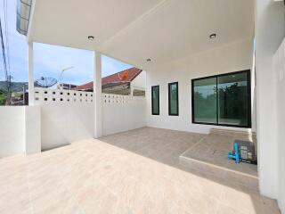 Spacious covered patio area with tile flooring and large windows