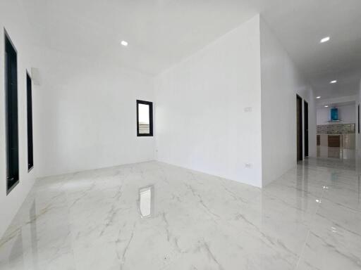 Spacious and bright living area with glossy marble flooring and white walls