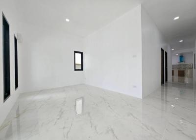 Spacious and bright living area with glossy marble flooring and white walls