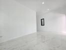 Spacious empty room with white marble flooring and bright lighting
