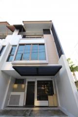 Modern multistory residential building facade with large windows and a front door