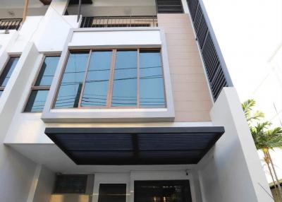 Modern multistory residential building facade with large windows and a front door