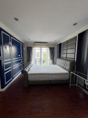 Elegant master bedroom with sophisticated blue and white theme and wooden flooring
