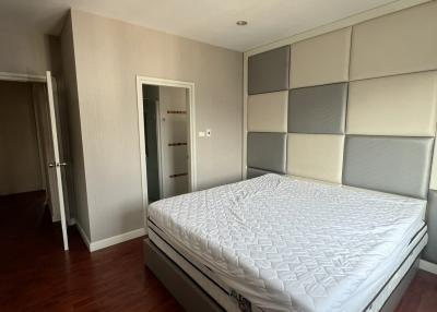 Spacious bedroom with a large bed and hardwood flooring