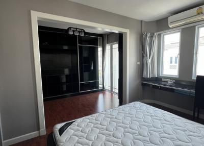 Spacious bedroom with modern lighting and hardwood floors