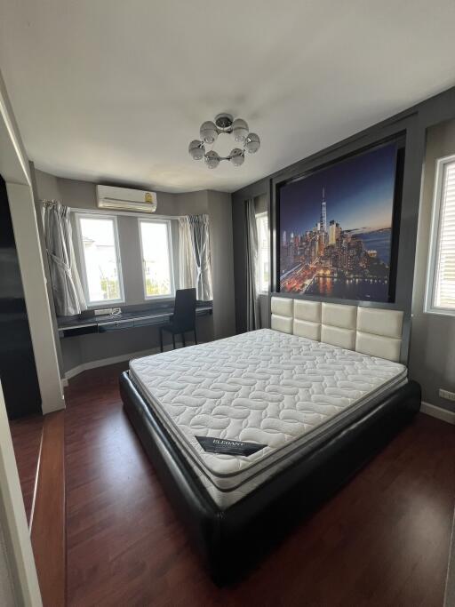 Modern bedroom with a large bed and cityscape wall mural