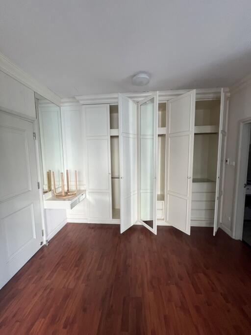 Empty bedroom interior with built-in wardrobes and hardwood floors