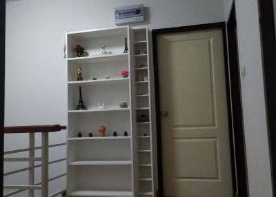 Cozy bedroom interior with white shelving unit and wooden flooring