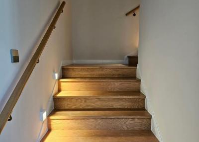 Elegant wooden staircase with wall lights