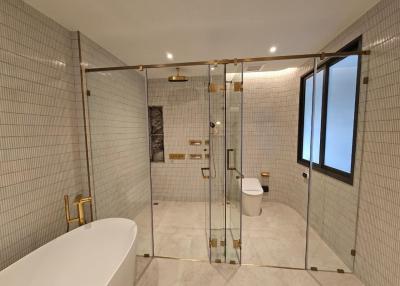 Modern spacious bathroom with glass shower and freestanding tub