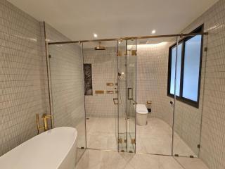 Modern spacious bathroom with glass shower and freestanding tub