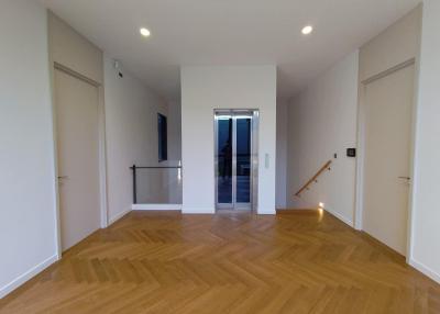 Spacious and well-lit empty room with wooden flooring