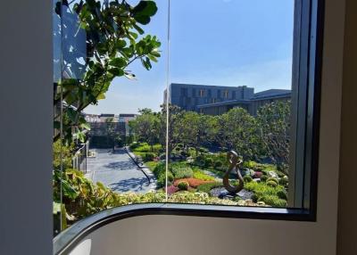 View from the window of a modern building showcasing greenery and architecture outside