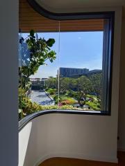 View from the window of a modern building showcasing greenery and architecture outside