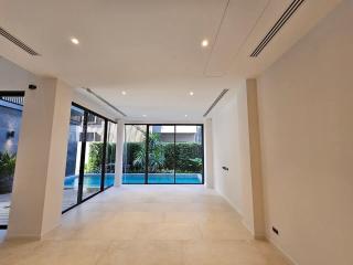 Spacious and modern living room with large windows overlooking a pool