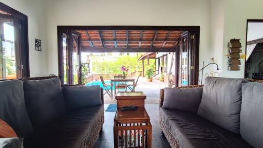 Spacious living room with open patio doors leading to an outdoor area