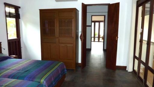 Spacious bedroom with wooden furnishings and tiled floor