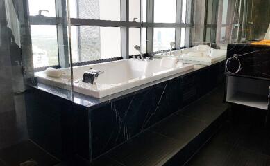 Modern bathroom with large marble bathtub and floor-to-ceiling windows