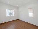 Empty bedroom with wooden floor and white walls