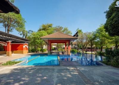 Luxurious outdoor swimming pool area with pavilion and lush greenery