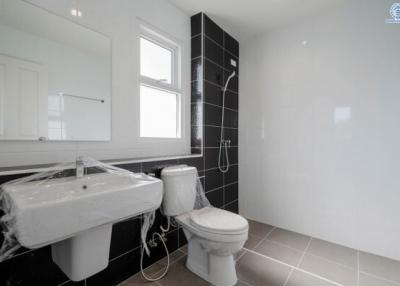 Modern bathroom with black and white tiles, including fixtures