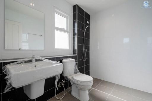 Modern bathroom with black and white tiles, including fixtures