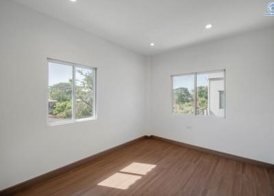 Spacious bedroom with hardwood floors and ample natural light