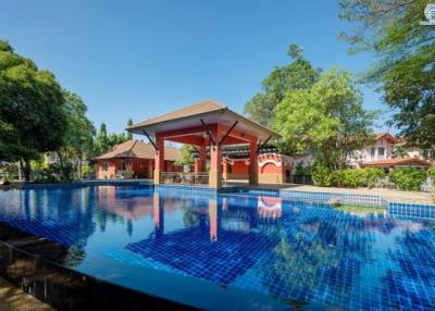 Elegant outdoor swimming pool area with surrounding greenery and residential buildings