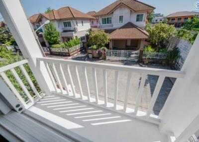 Balcony view overlooking neighboring houses with clear skies