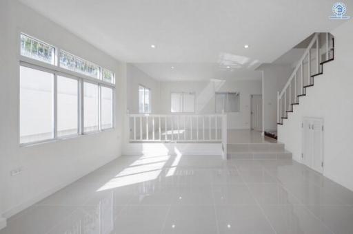 Bright and spacious living area with staircase and large windows