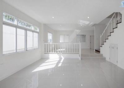 Bright and spacious living area with staircase and large windows