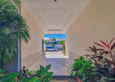 Spacious entryway of a modern building with tiled flooring and lush green plants